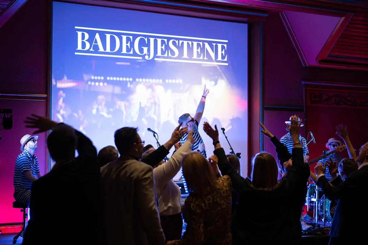 Publikum på fest med armene i været